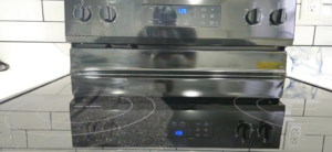 A sparkling clean stovetop and oven, reflecting light, showcasing professional results from Legacy Signature Clean in Mobile, AL.