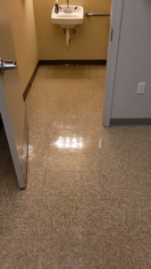 A sparkling clean and reflective tiled floor in a restroom, showcasing the quality cleaning services by Gavin's Cutting Edge in Moscow, ID.