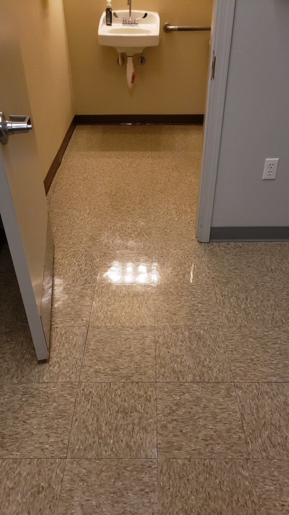 A sparkling clean and reflective tiled floor in a restroom, showcasing the quality cleaning services by Gavin's Cutting Edge in Moscow, ID.