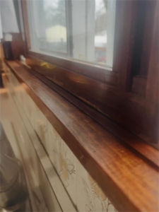 A sparkling clean wooden window sill and frame, showcasing attention to detail by BLACK PEARL Cleaning CO. in Greenwood, MO.