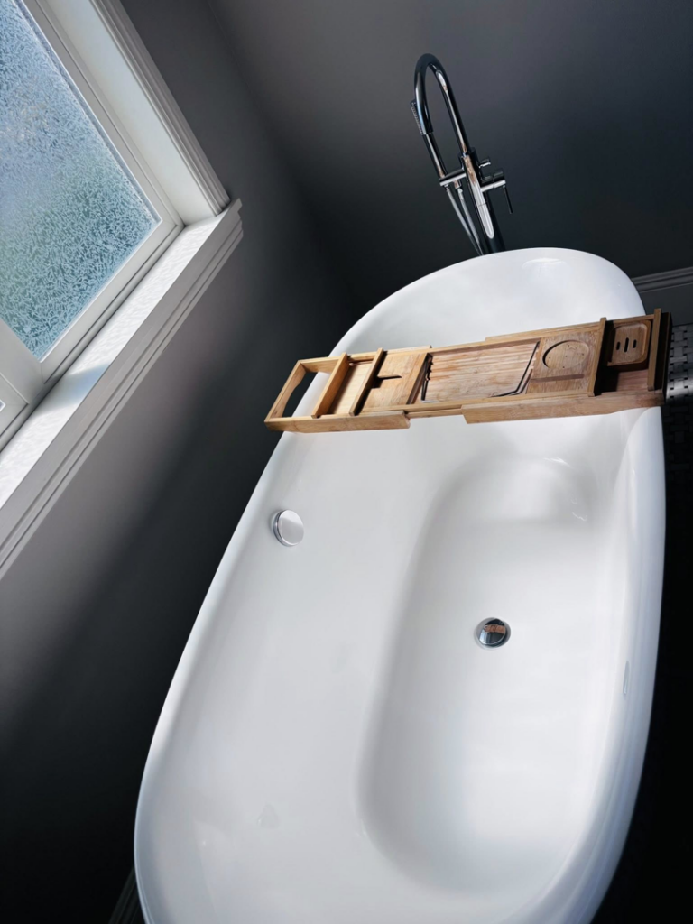 A sparkling clean freestanding bathtub with a wooden caddy, showcasing the deep cleaning by Clean departure Cleaning service in Reseda, CA.