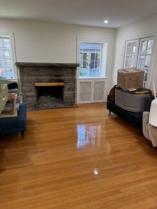A living room featuring sparkling hardwood floors and a stone fireplace, cleaned by Statewide cleaning services llc in Philadelphia, PA.