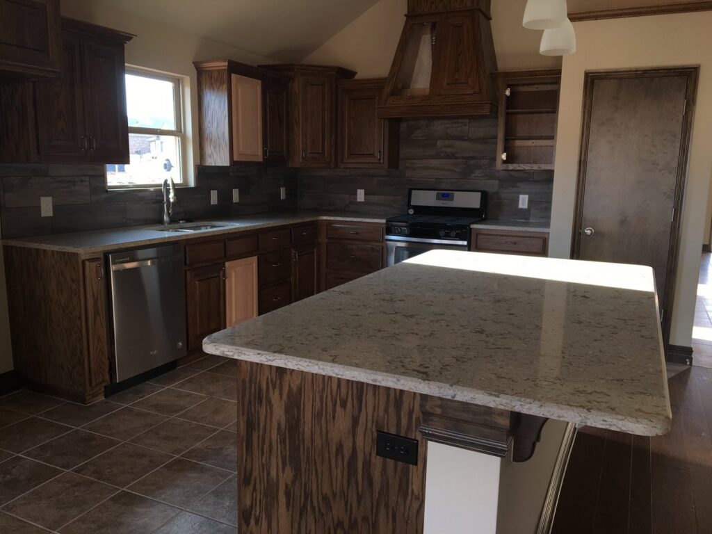 A sparkling clean kitchen with dark wood cabinets and a large island by Pristine Cleaning Concepts in Stillwater, OK.