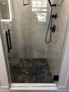 A sparkling clean tiled shower with clear glass, demonstrating the thorough cleaning by Polished Housekeeping Services in Londonderry, NH.