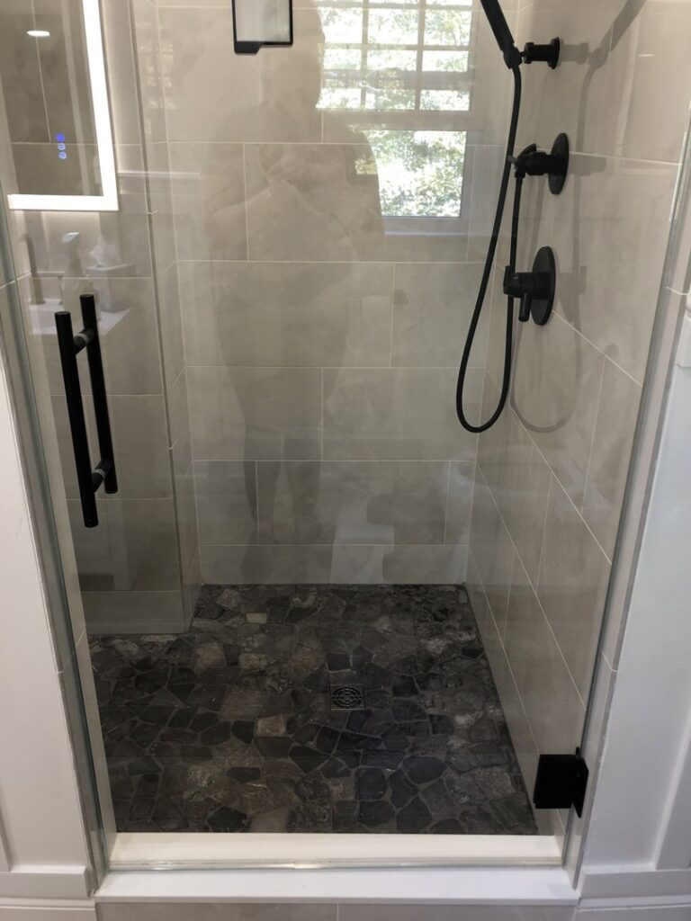 A sparkling clean tiled shower with clear glass, demonstrating the thorough cleaning by Polished Housekeeping Services in Londonderry, NH.
