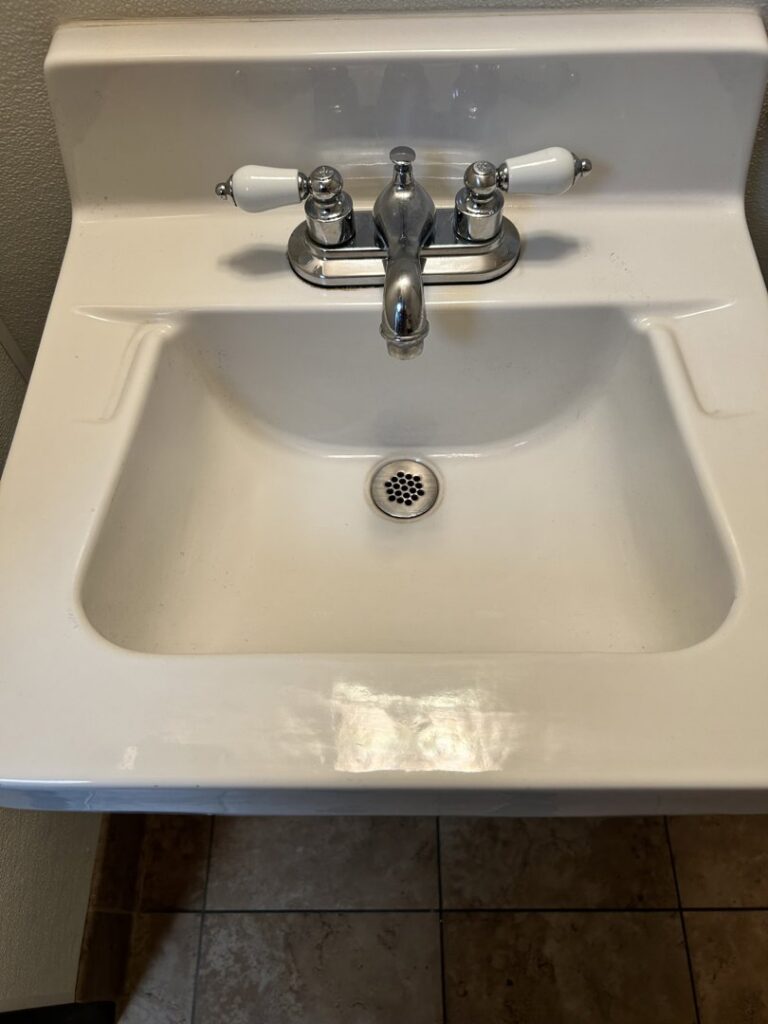 A sparkling white bathroom sink with chrome faucet, professionally cleaned by Green Leaf Janitorial in Gilbert, AZ.