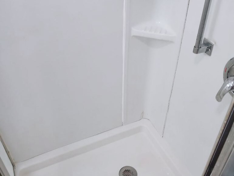 A sparkling white shower stall, meticulously cleaned by Sanchez Cleaning Service, LLC in San Antonio, TX.