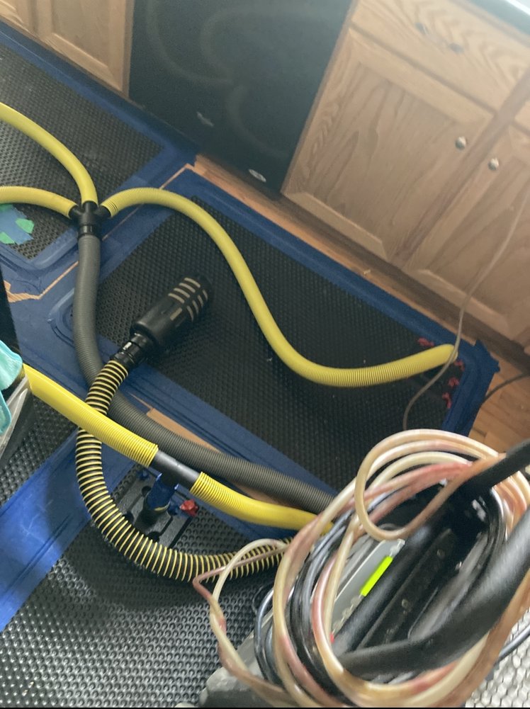 Specialized hoses and drying equipment laid out on a floor for water damage restoration by Flood Pros in Sandy, UT.