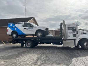 A Spectrum service truck loaded onto a flatbed tow truck from Wilkerson's Towing & Automotive LLC in Bowling Green, KY.