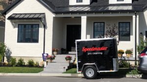 A Speedmaster Pro Cleaning trailer parked in front of a modern house, indicating on-site house cleaning services in Salt Lake City, UT.