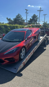 A red sports car being towed on a flatbed truck by Citywide Towing Services in Dearborn, MI.
