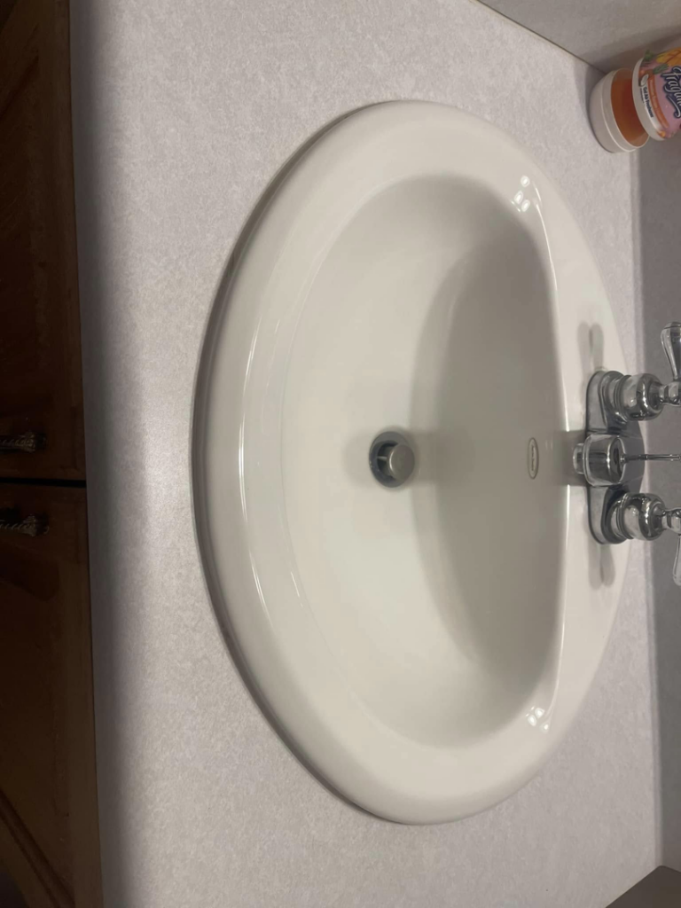 A spotless white bathroom sink and countertop, demonstrating the meticulous cleaning by The Clean Solution in Eagle Lake, TX