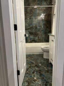 A spotless bathroom featuring unique blue and brown hexagonal floor tiles, expertly cleaned by Cleaning Sisters LLC in Richmond, VA.