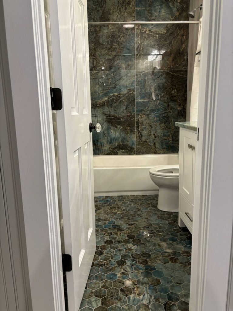 A spotless bathroom featuring unique blue and brown hexagonal floor tiles, expertly cleaned by Cleaning Sisters LLC in Richmond, VA.