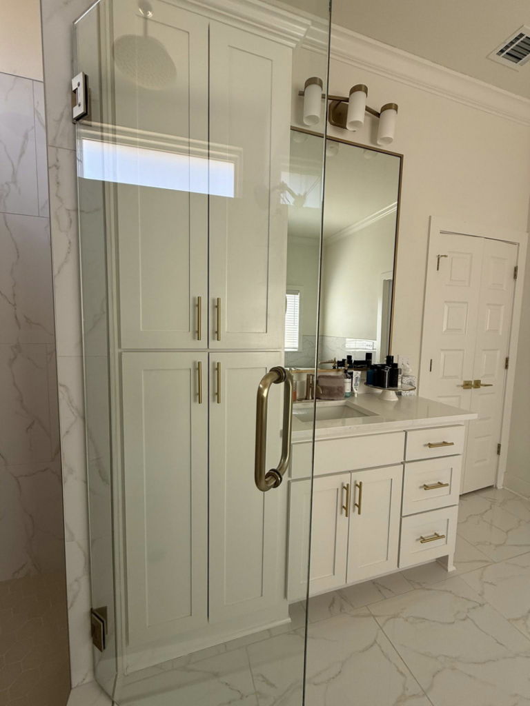 A spotless bathroom with a clean vanity, mirror, and glass shower, maintained by Global Provisions, AR in Fayetteville, AR.
