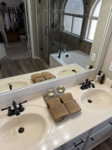 A spotless bathroom vanity with double sinks and neatly folded towels, cleaned by Lupita's cleaning services in San Antonio, TX.