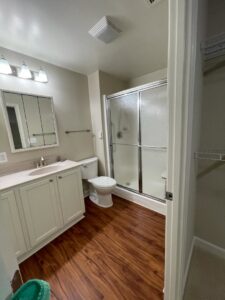 A spotless bathroom featuring a glass-enclosed shower, toilet, and vanity, showcasing the thorough cleaning by Rivas Molina's Cleaning LLC in Dundalk, MD.