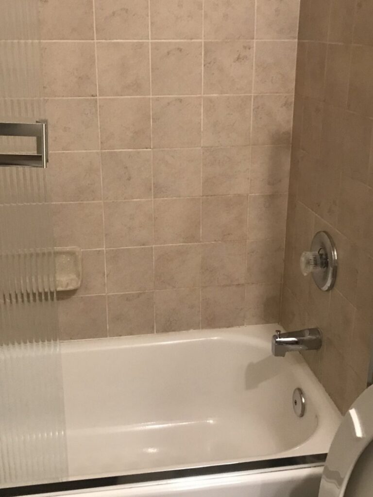 A spotless bathtub and tiled shower wall, reflecting the thorough house cleaning provided by A Clean Xscape LLC in Chandler, AZ.