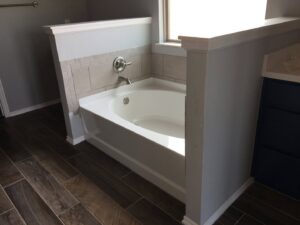 A spotless white bathtub and tiled walls after a thorough bathroom clean by Pristine Cleaning Concepts in Stillwater, OK.