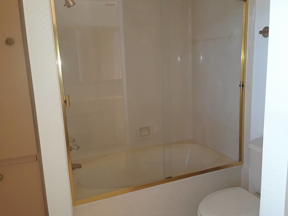 A spotless bathtub and glass shower enclosure in a clean bathroom, provided by Inside & Out Residential Cleaning & Lawn Care in Yulee, FL.