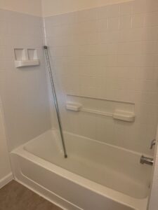 A spotless white bathtub and clean tiled shower walls, demonstrating thorough bathroom cleaning by 307 Maid in Cheyenne, WY.