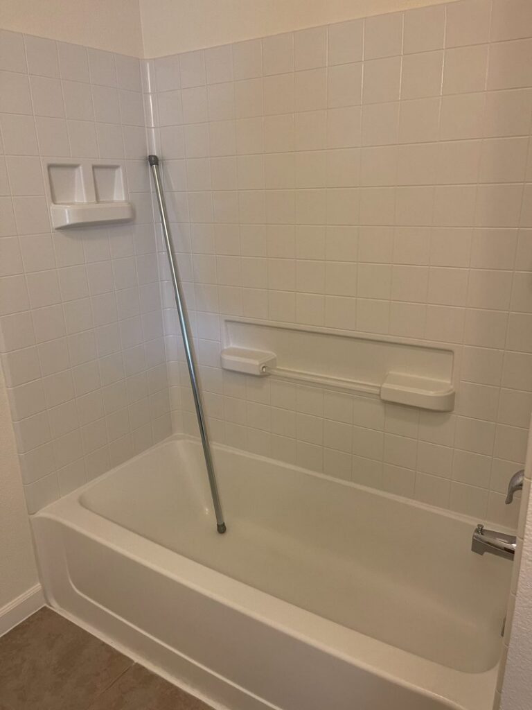 A spotless white bathtub and clean tiled shower walls, demonstrating thorough bathroom cleaning by 307 Maid in Cheyenne, WY.