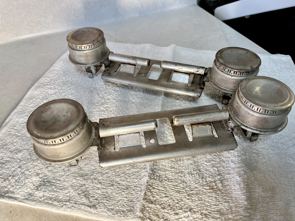 Spotless clean stove burner components resting on a towel, after professional cleaning by Masters Touch Cleaning Solutions LLC.