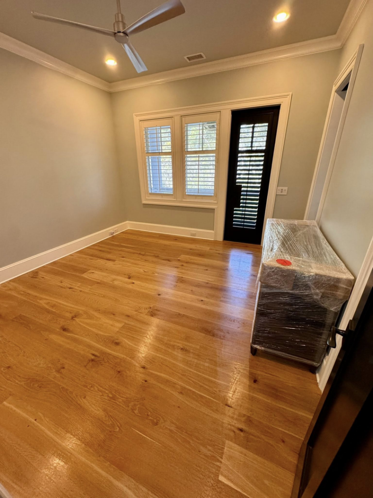 A spotless empty room with gleaming hardwood floors, cleaned by Affordable Cleaning in North Charleston, SC.