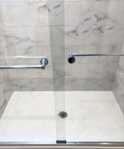 A spotless glass shower door and clean tiled walls, showcasing the detailed work of Polished Housekeeping Services in Londonderry, NH.