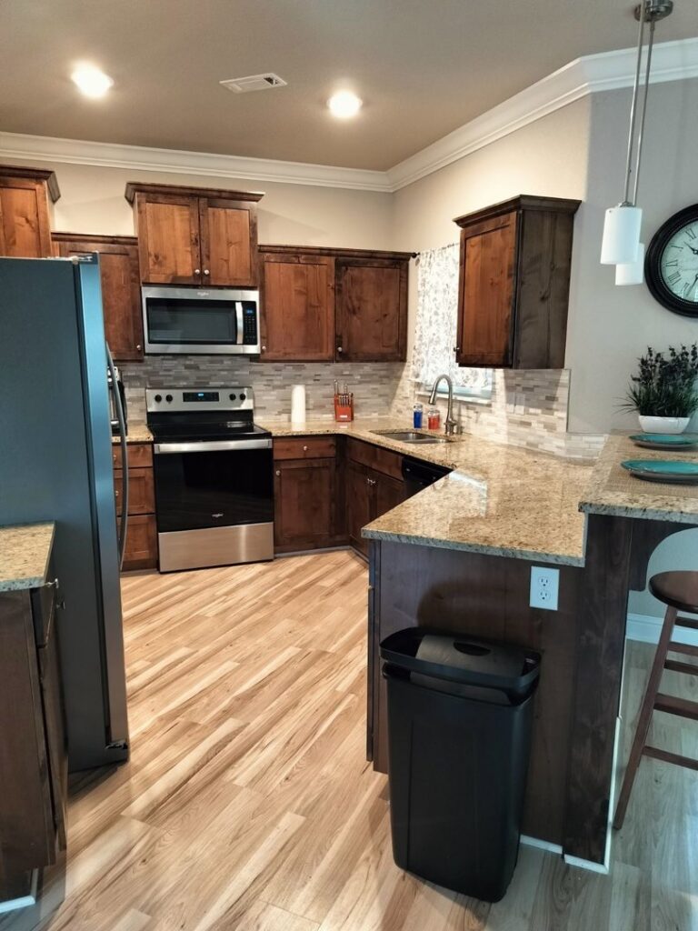 A spotless kitchen featuring dark wood cabinets and granite countertops, expertly cleaned by Peoria Cleaning Pros, LLC in East Peoria, IL.
