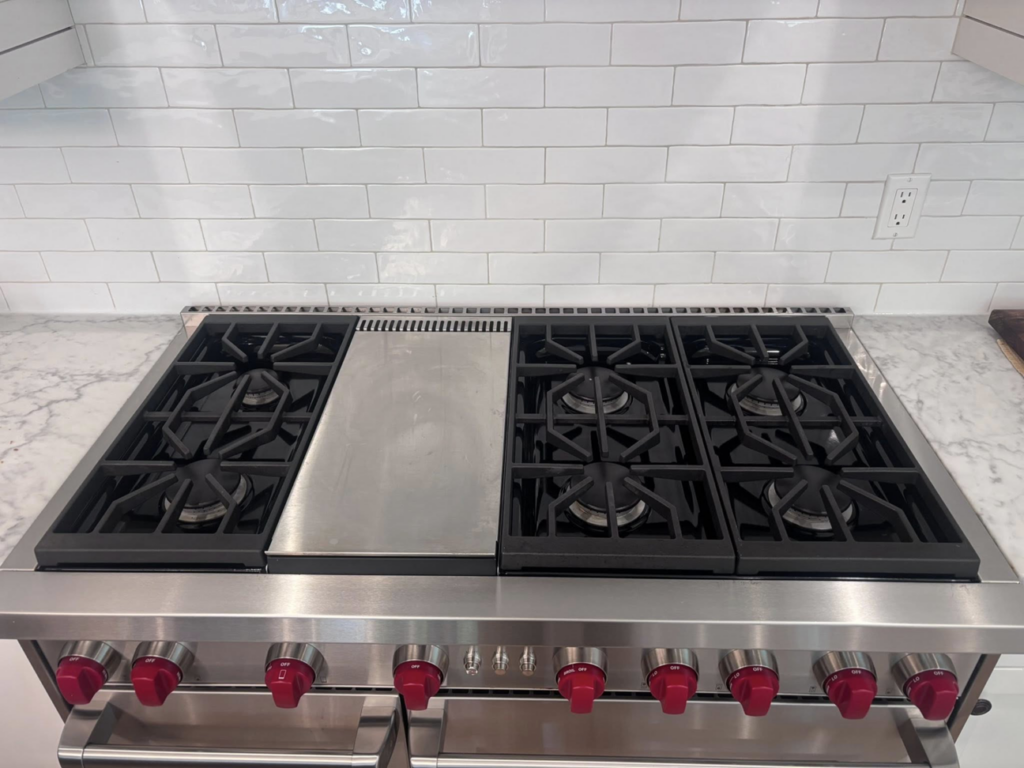 A spotless and shiny kitchen stove top with grates, demonstrating the quality of Clean departure Cleaning service in Reseda, CA.