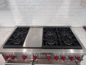 A spotless and shiny kitchen stove top with grates, demonstrating the quality of Clean departure Cleaning service in Reseda, CA.