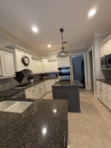 A spotless kitchen with a clean sink and white cabinets, professionally cleaned by Cleaning by Design LLC in Frederick, MD.