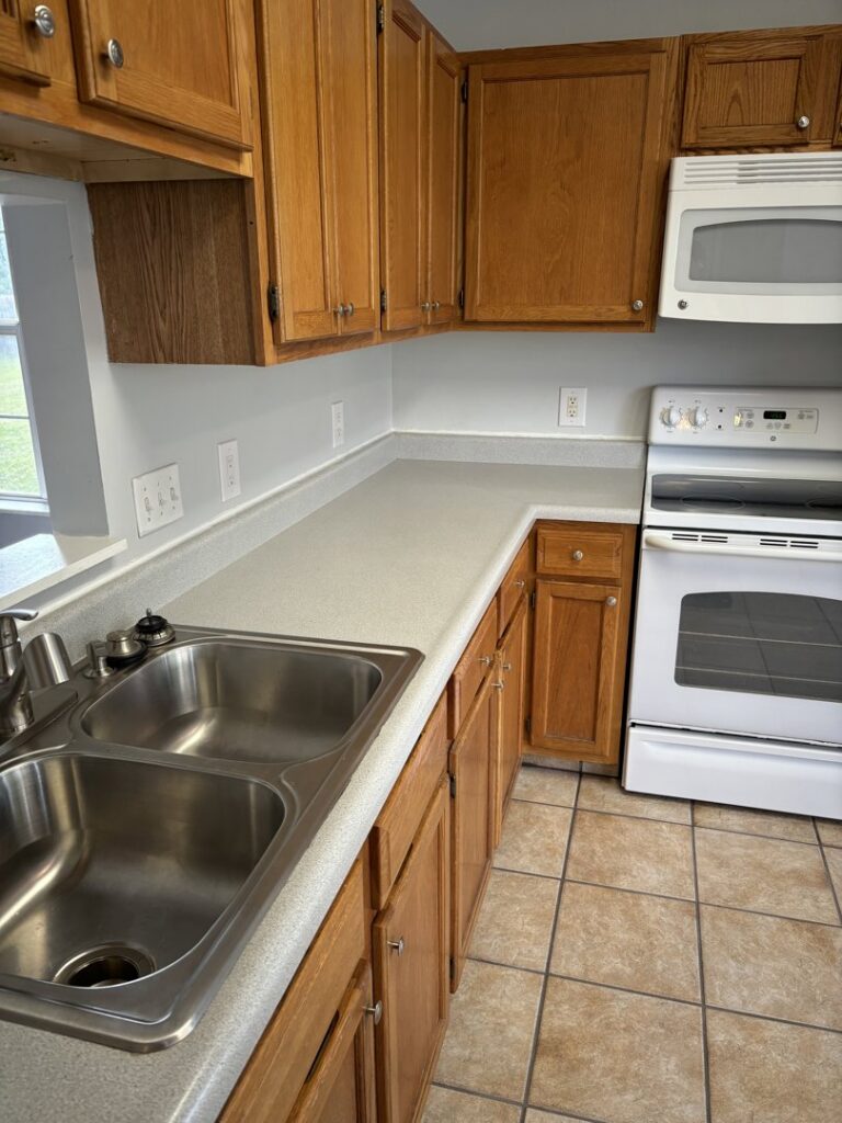 A spotless kitchen featuring wooden cabinets and light countertops, professionally cleaned by Maid In Indy in Indianapolis, IN.