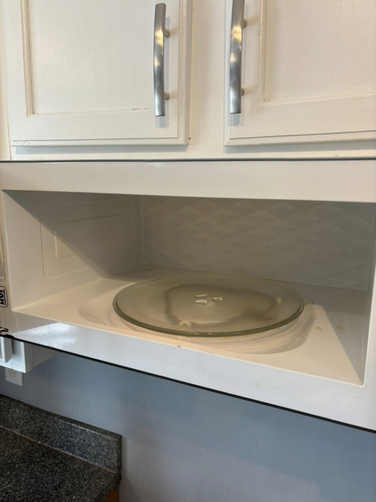A spotless and thoroughly cleaned microwave interior with a glass turntable, demonstrating the detailed work of Claudia's Cleaning Services in Clarksville, TN.