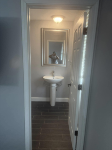 A spotless powder room bathroom with a pedestal sink, cleaned by Chelle's Cleaning Services in Gary, IN.