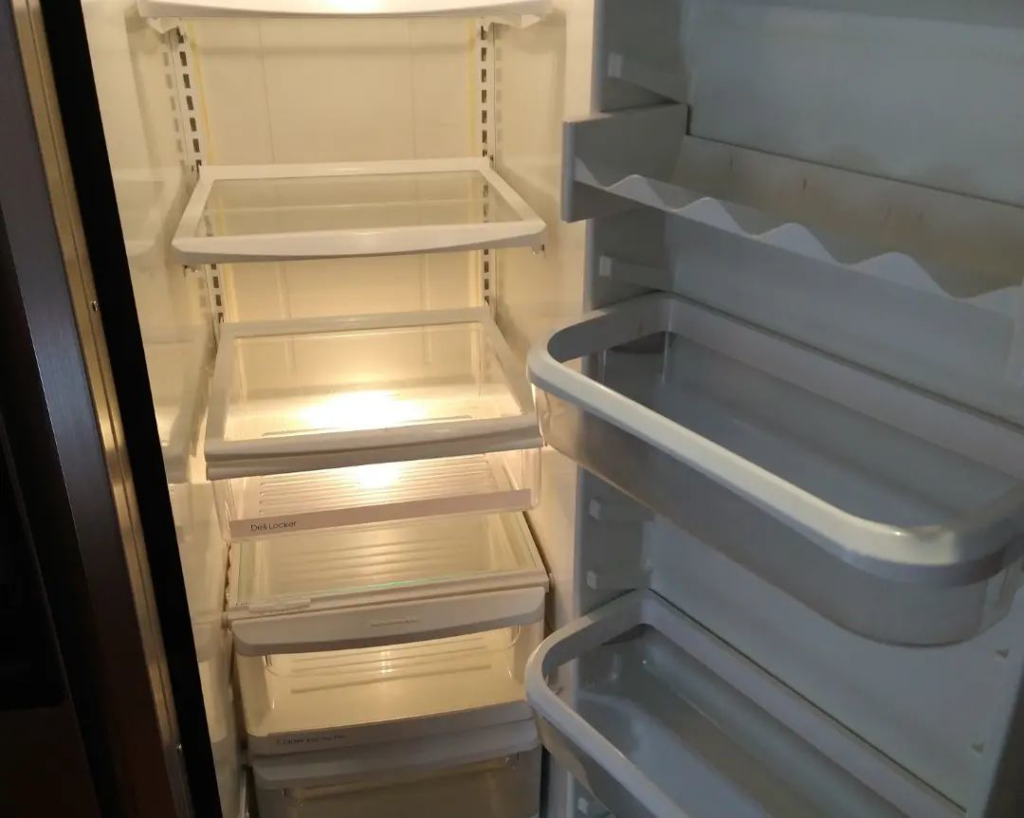 The spotless interior of a refrigerator with clean shelves and drawers, cleaned by Sunrise Cleaning in Saint Petersburg, FL.