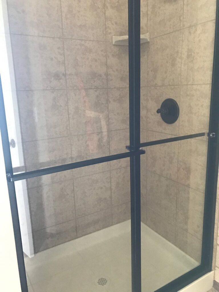 A spotless shower stall with clean tiles and glass door, expertly cleaned by Pristine Cleaning Concepts in Stillwater, OK.