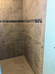 A spotless tiled shower in a residential bathroom, showcasing the cleaning expertise of Price Cleaning Services Omaha in Council Bluffs, IA.