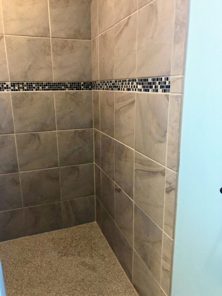 A spotless tiled shower in a residential bathroom, showcasing the cleaning expertise of Price Cleaning Services Omaha in Council Bluffs, IA.