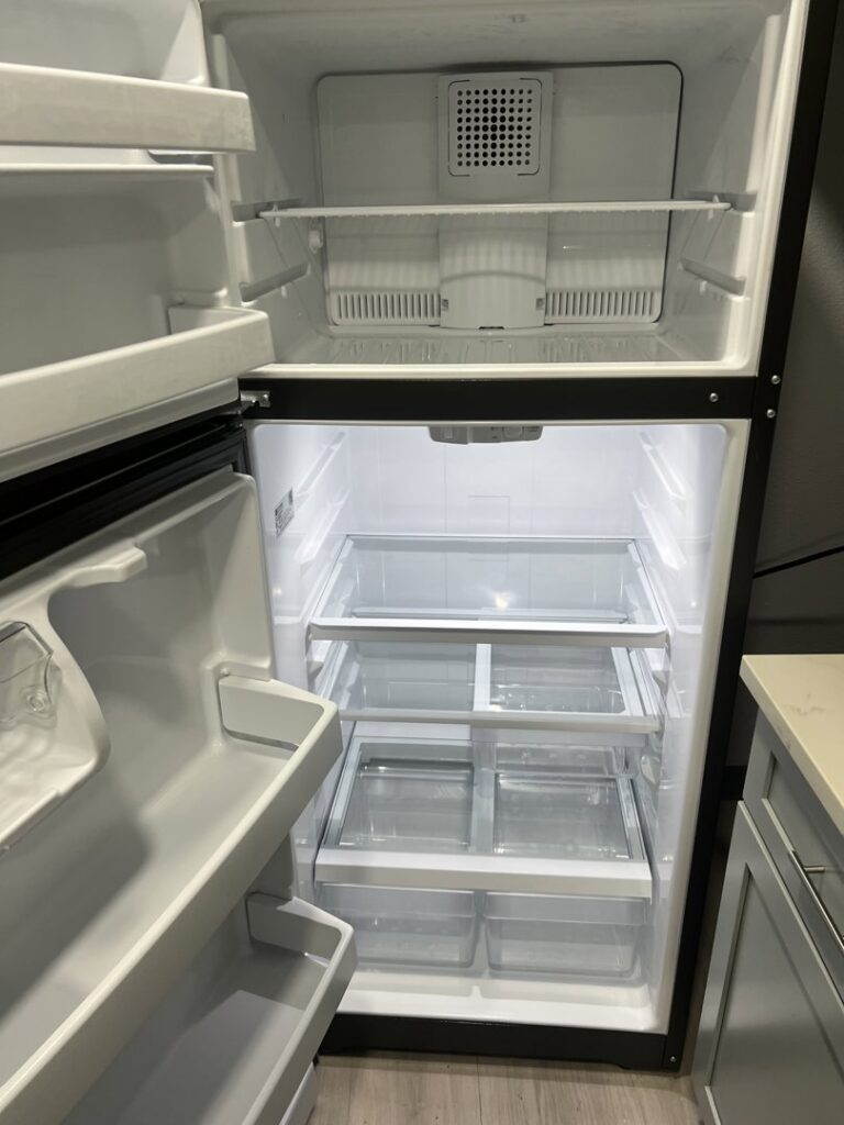 An open, spotless top-freezer refrigerator, showcasing the deep cleaning services of JBO Cleaning Services in Belle Chasse, LA.
