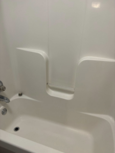 A spotless white bathtub and shower surround, showcasing the pristine bathroom cleaning services offered by Claudia's Cleaning Services in Clarksville, TN.