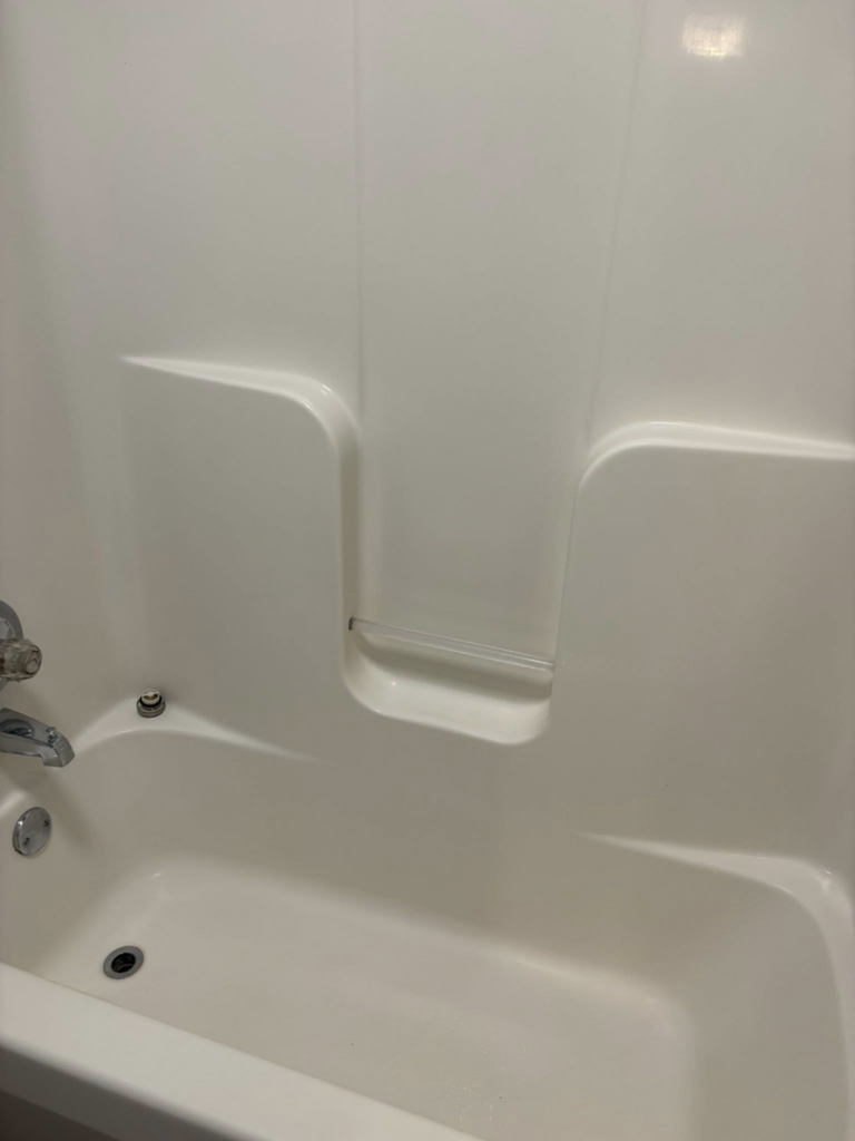 A spotless white bathtub and shower surround, showcasing the pristine bathroom cleaning services offered by Claudia's Cleaning Services in Clarksville, TN.