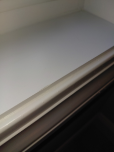A close-up of a spotless window sill after professional cleaning by White Lotus Cleaning Services LLC in Nashua, NH.