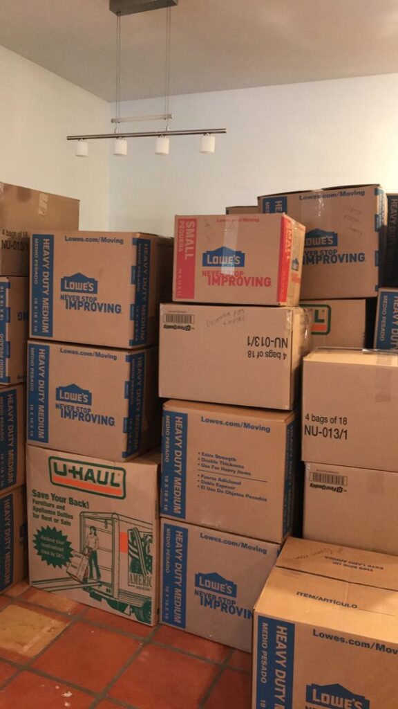 Neatly stacked moving boxes from Lowe's and U-Haul inside a room, indicating a recent move by Academy Movers in Gilbert, AZ.