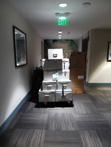 A stack of moving boxes on a dolly in a hallway, ready for transport by Rough Çutt Movers in San Diego, CA