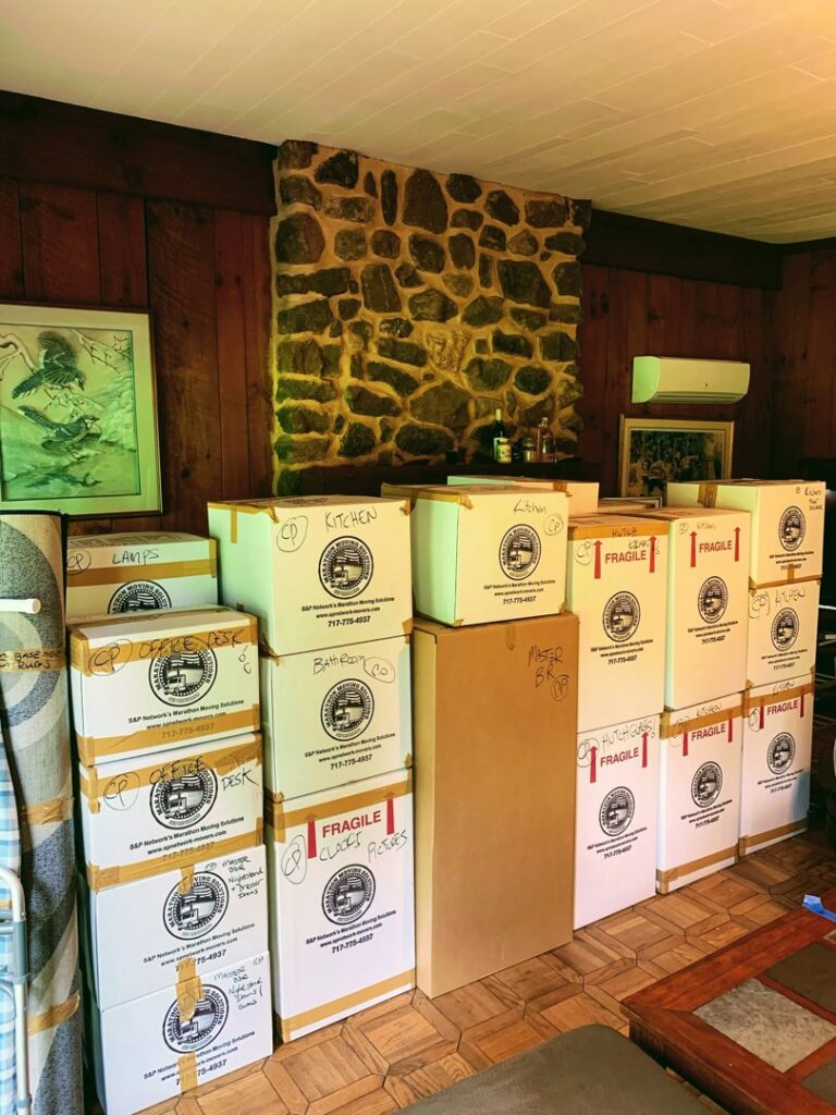 Stacks of moving boxes, some labeled "Fragile" and branded with S&P Network's Marathon Moving Solutions in Mechanicsburg, PA.