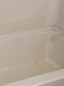 A stained bathtub showing dirt streaks before cleaning by Jenny Can Cleaning Company in Canton, OH