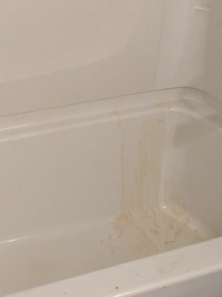 A stained bathtub showing dirt streaks before cleaning by Jenny Can Cleaning Company in Canton, OH