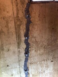 A stained and cracked concrete wall, indicating water damage that requires specialist attention from Northeast Wisconsin Waterproofing, LLC in Green Bay, WI.